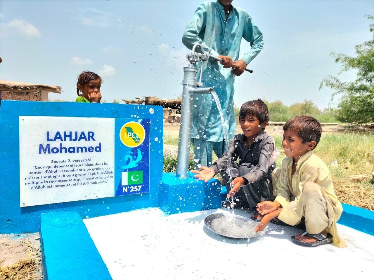Children playing with water from a pump.